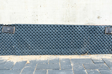 Foundation waterproofing with protective dimpled drainage membrane installed around concrete wall...
