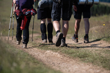 Obraz premium Hikers walking on dirt trail in countryside