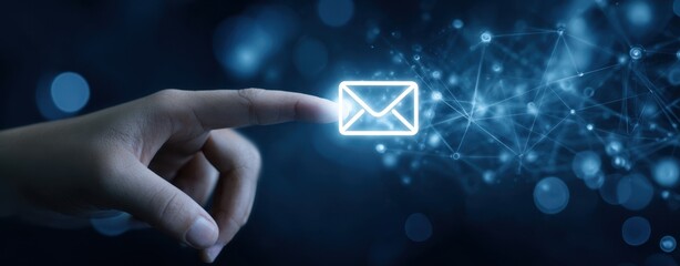 The hand reaching towards a glowing digital email icon in blue light.