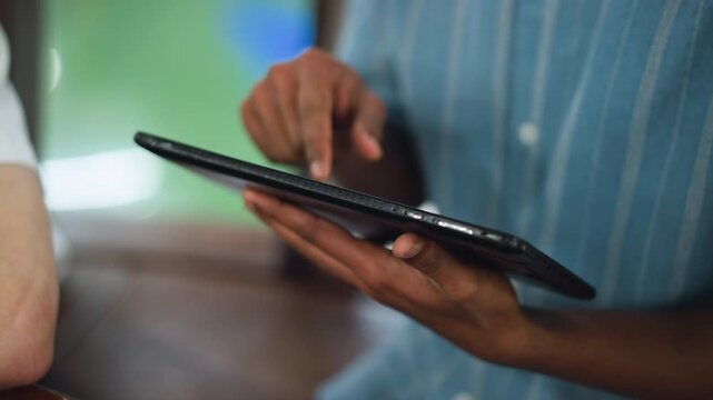 Tight closeup of hand dabbing fingertip on tablet screen while ink sketch lies nearby subtle motion blur captures delicate interaction between touch and canvas digital tool meets analog art