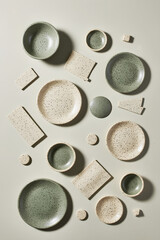 Fototapeta premium Elegant speckled dinnerware arranged artistically on a neutral backdrop showcasing various sizes and shapes of plates and bowls