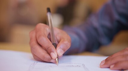 Close-up hand holding pen writing on paper, focus on fingers and ink tip, adult person taking notes or filling document, blurred background, educational or professional context, concentration scene