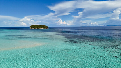 Remote island with lush greenery and calm ocean, representing adventure and relaxation in Raja...
