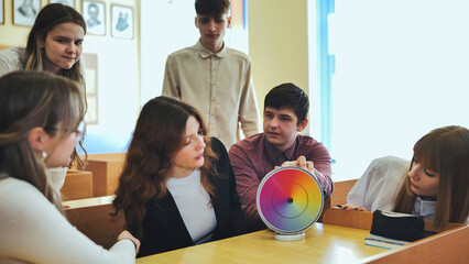 Students in physics class spin Newton's multicolored disk.