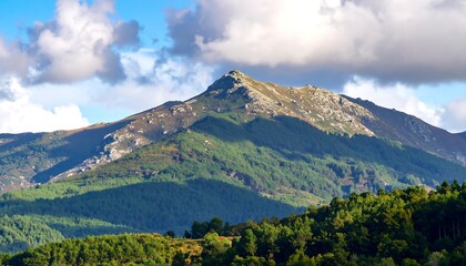 Fototapeta premium Verdant mountain range under a partly cloudy sky