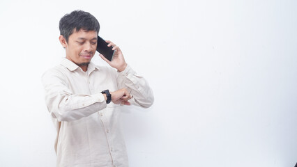 Asian man looking at his smartwatch white make a phone call