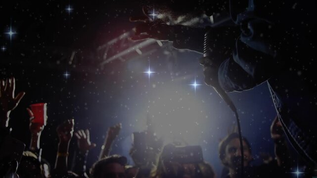 Emerging in pulsing light performer leaning over fans holding microphone singing for concert vibe