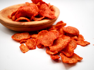 Close-up of Indonesian fried basreng crackers seasoned with chili powder on white background,...