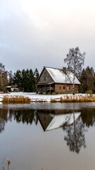 Fototapeta premium Rustic wooden house reflected in calm winter water