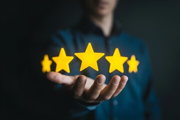 A person holding five yellow stars in their hand against a dark background in a close up shot