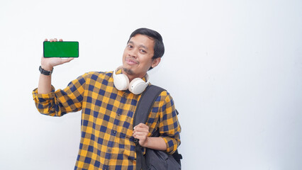 Asian student showing green screen smartphone on white background