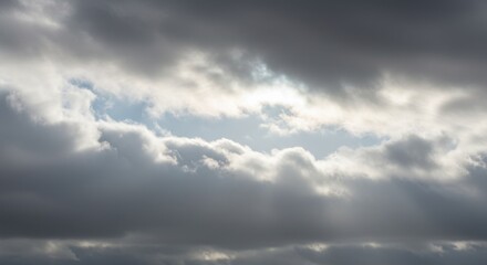 Fototapeta premium Dramatic Gray and White Cloudscape with Sunlight Breaking Through