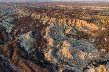 Golden hour sunlight illuminates the rugged terrain of national park, revealing its unique geological formations