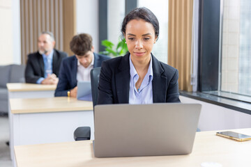 Obraz premium African american business woman working with laptop in modern meeting room. Multi-Ethnic Corporate Business Meeting. Female executive handling real estate project. Financial analysis.