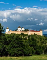Fototapeta premium Fortress perched on a hilltop, surrounded by trees
