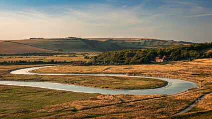 August evening golden hour over the Cuckmere river within the Seven Sisters country park on the...