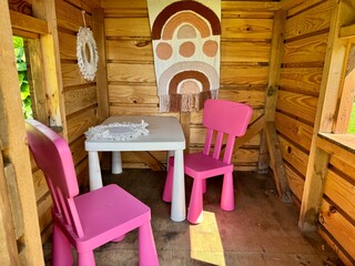 A wooden playhouse for children featuring a fully furnished interior, inspire imaginative play 