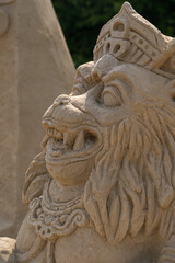 Face of a monkey sculpted from sand.
