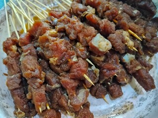 a collection of uncooked beef satay