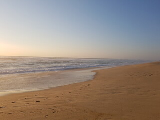 A soothing coastal landscape where warm sand meets the blue sea and horizon, perfect for travel and serenity themes