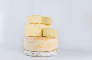 cheese heads of different kinds stacked on table