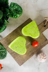 handmade cheese head with pesto in the shape of a heart on a cutting board
