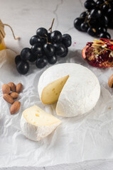 Camembert cheese with white mold, walnuts, honey and dried fruits. Dinner or aperitif concept.