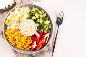 Salad of chopped crab sticks with sweet corn, eggs, cucumber nd sause mayonnaise