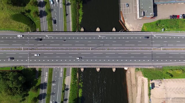 Utrecht, Utrecht region, Netherlands - 09.06.2025: Aerial view of a modern cityscape with a river, industrial buildings, boats, and residential areas. A busy road with a bridge crosses the water