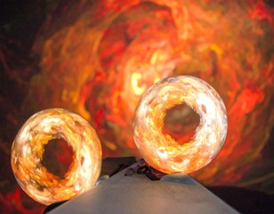 Two glowing orbs against a fiery backdrop