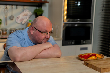 A skilled chef thoughtfully engaging with fresh ingredients in a modern kitchen, preparing a meal
