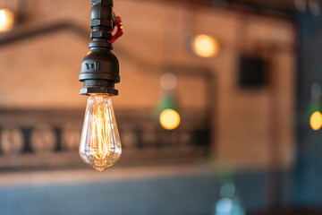 A classic design ceiling fluorescent lightbulb is glowing in orange warm light. Interior decoration...