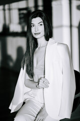 Elegant model poses with confidence in a chic outfit during an indoor photoshoot in soft light