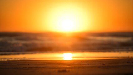 Serene beach sunset with golden tones and a softly focused horizon, creating a peaceful atmosphere.