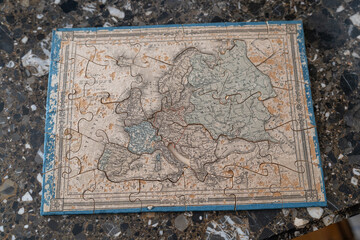 An old puzzle assembled on a table, featuring a map of the continents — a tactile journey across the world.
