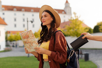 Travel and pickpocketing. Thief stealing wallet from woman tourist backpack while lady looking...