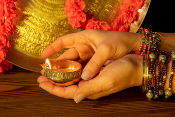 Hands with Diwali lamp diya or Deepavali or Deepawali. Hindu festival of lights. Celebrating in...