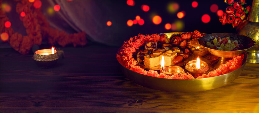 Tray with Diwali treats. Diwali lamp diya or Deepavali or Deepawali. Hindu festival of lights. Celebrating in Indian religions Jainism and Sikhism. Offering to the gods. Close up view, out of focus