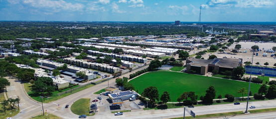 Panorama aerial view flat roofed low rise apartment complex with green space field in Richardson, Texas, prominent telecommunication tower supports cellular, broadband, enterprise data traffic