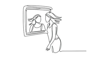 Woman admires her reflection in a mirror with her hair blowing