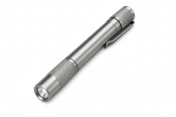 Compact metal flashlight positioned against clear surface, illuminating emergency preparedness