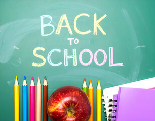 Back to school concept background. Chalkboard with colored pencils, an apple, and notebooks. Flat lay of stationery and supplies for education, students, and teachers. Generative AI