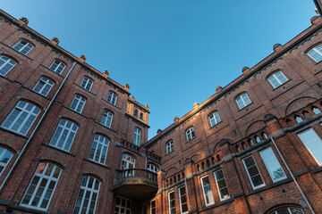 Dramatic upward perspective of historic brick courtyard showing multiple building levels and traditional architectural details