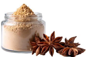 Glass jar filled with ground spice powder, surrounded by star anise pods on a white background