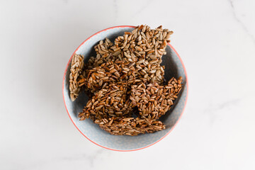 Crunchy sunflower seed crisps sweetened with stevia served in a blue patterned bowl. Perfect...