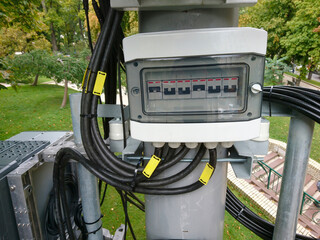 Detailed shot of an electrical panel with multiple cables and circuit breakers, showing outdoor...