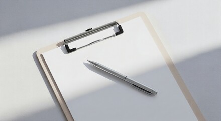 Minimalist office workspace with a clipboard holding blank white paper and a pen, bathed in natural light creating distinct shadows