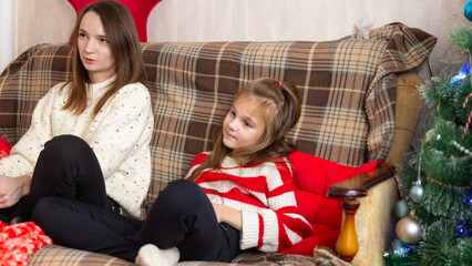 Happy family mother and daughter laugh and play video games together using a video game console on...