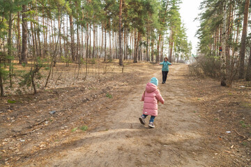 grandmother with granddaughter walking and playing in nature in the forest