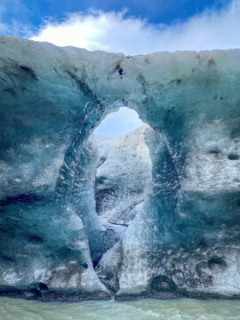 Close-up of a natural ice arch with translucent blue textures at the edge of Breidamerkurjokull glacier in Iceland